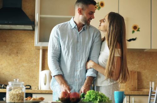 Portrait of loving couple cooking breakfast smiling in the kitchen at home